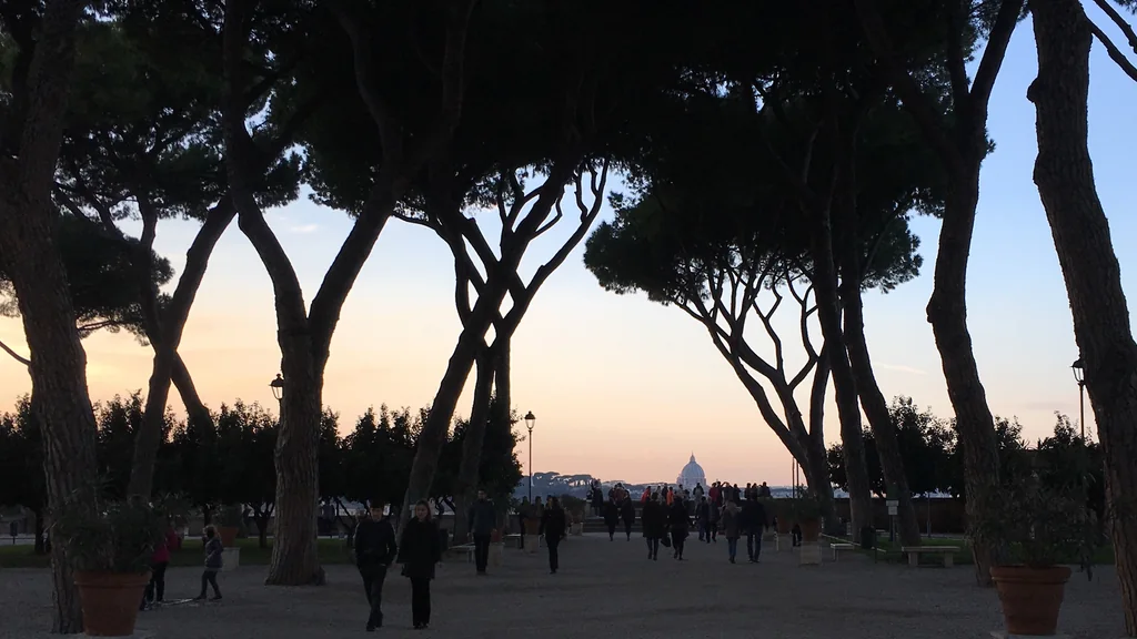 Giardino degli Aranci sull’Aventino a Roma al tramonto, con i pini e la cupola di San Pietro sullo sfondo